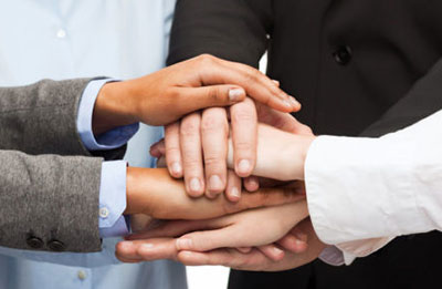 group of professionals stacking their hands together