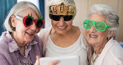 three elderly women wearing silly glasses for respite care page