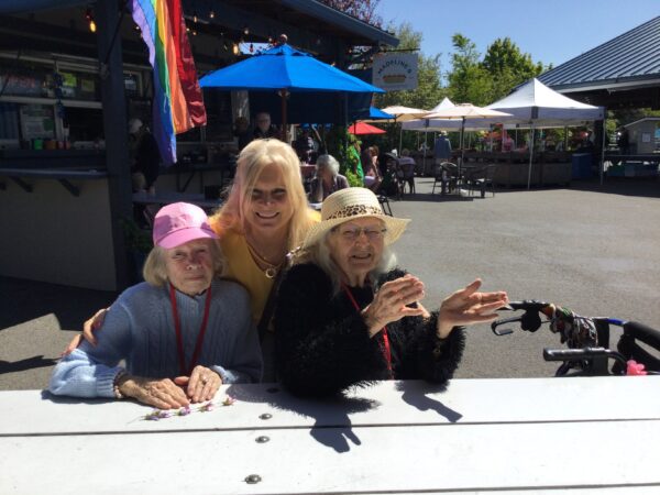 three elders enjoying sunshine at farmers market